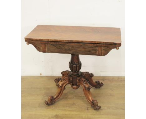 A Victorian rosewood fold over Card Table with red baize lined surface and mounted upon gadrooned pillar with four scroll sup