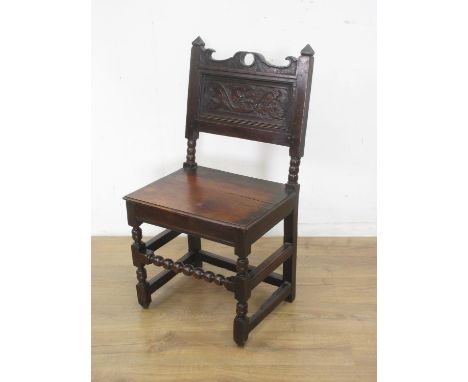 A 17th Century oak Side Chair with shaped top rail, leafage scroll carved panelled back, solid seat on turned and square fron