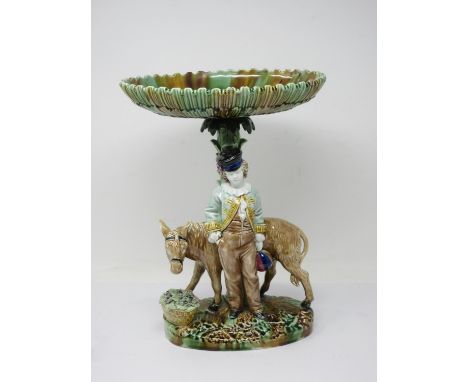 An English majolica Comport with oval dish top, fluted edge on tree trunk support with standing figure of boy and donkey, on 