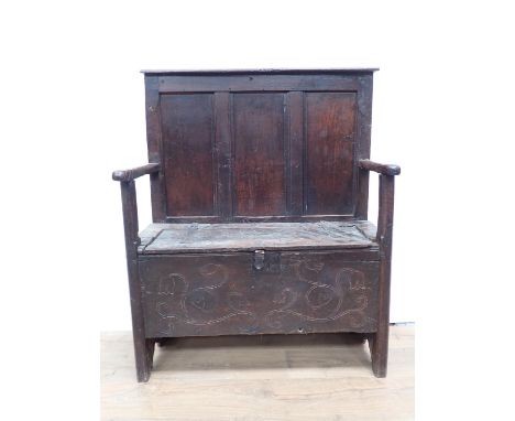 A 17th Century oak three panel Settle with box seat converted from a six plank chest with south west England tulip carving on