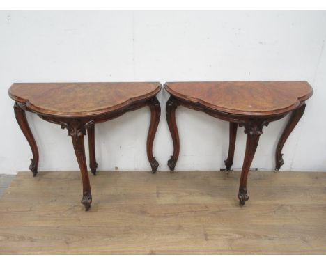 A pair of Victorian walnut fold-over Card Tables of trefoil shape with green and red baize interior surfaces, mounted upon le