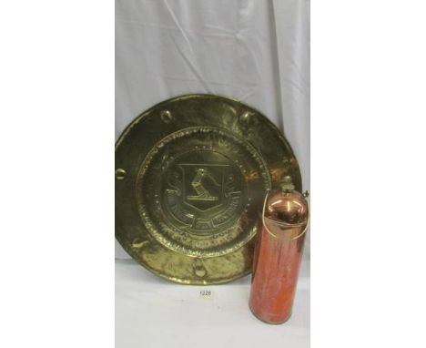An Army &amp; Navy stores copper flask and a large brass wall plaque depicting a coat of arms.
