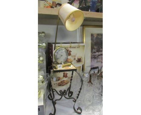A retro alarm clock/lamp and a wrought iron stand with tiled top.