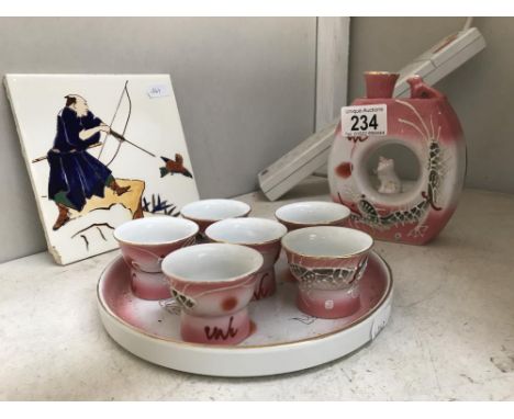 A modern Japanese saki set with 6 cups with pictures to base &amp; a painted tile featuring Japanese hunter