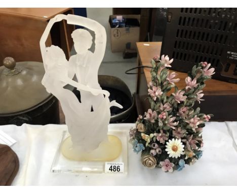 An acrylic dancers figure and a ceramic floral decoration.