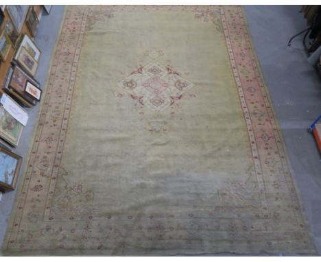 A LIGHT GREEN GROUND EASTERN RUG, with central medallion and pink border, 554cm x 403cm Condition Report: Available upon requ