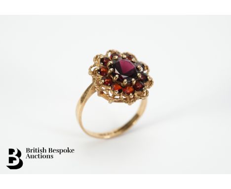 Vintage 9ct gold floral garnet ring. The ring set with a central garnet of 8mm, surrounded by ten 2mm garnets, mm C.L &amp; S