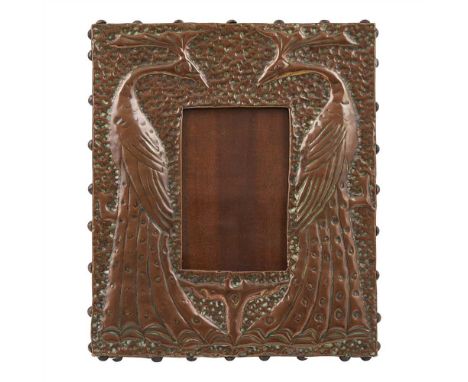 GLASGOW SCHOOL  REPOUSSÉ COPPER ‘PEACOCK’ PHOTOGRAPH FRAME, CIRCA 1900 chased with a pair of opposing peacocks on a hand-beat
