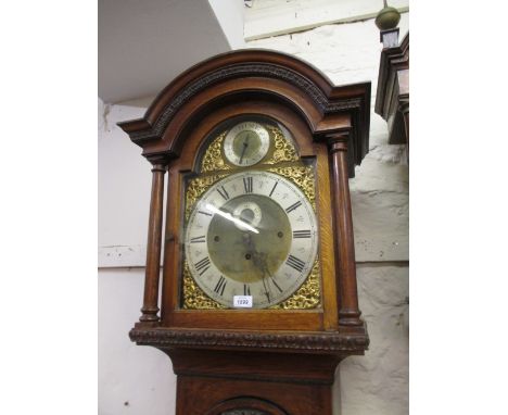 Late Victorian oak longcase clock, the arched hood with turned columns above an arched door with floral carved panels and a p