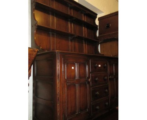 Ercol dark ash dresser having shelved back above four central drawers and two panel doors on stile end supports