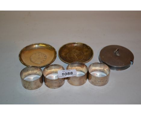 Set of four plain silver napkin rings, two silver coin inset trinket dishes and a Chester silver lid