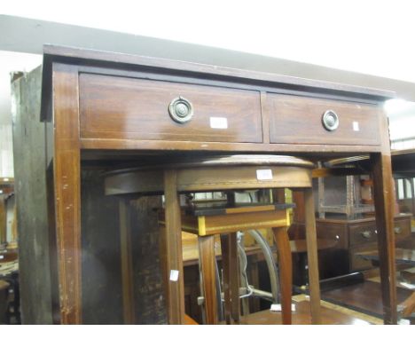 Edwardian mahogany two drawer side table with ring handles, on square tapering supports with brass and ceramic casters