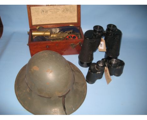 Two pairs of binoculars, a tin helmet and a mahogany cased electric shock machine