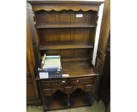 20th Century oak dresser having moulded top above shelved back above an arrangement of five short drawers on baluster turned 