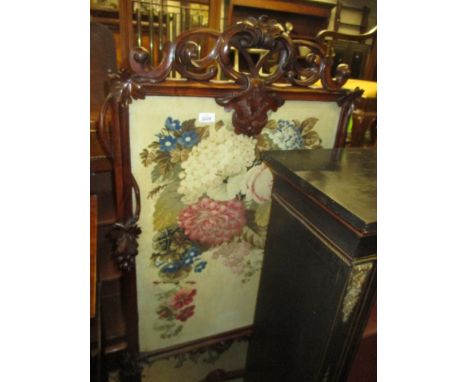 Victorian carved walnut fire screen inset with a needlework panel of flowers