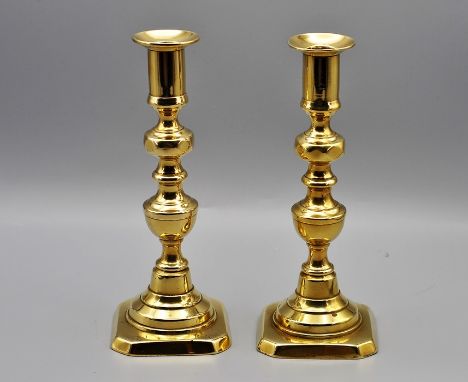 A pair of 18th century brass candle stick holders, approximately 20cm tall