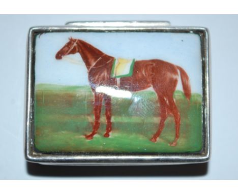 A silver and enamel topped pill box with racing horse decoration to top