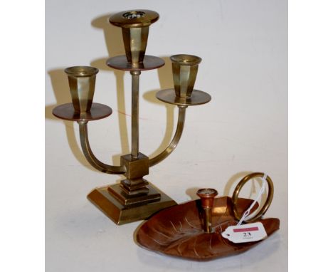 An Arts & Crafts copper and brass chamberstick, and a brass three light candelabrum (2)
