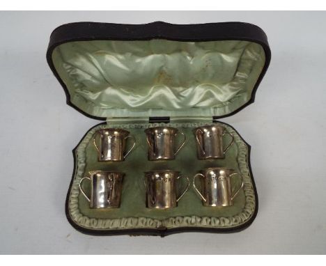 A George V cased set of six silver tots of tyg form, Birmingham assay 1927, sponsors mark for Williams (Birmingham) Ltd, appr