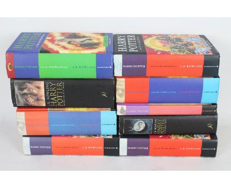 A collection of hardback Harry Potter books, including first editions.