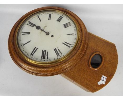 A late 19th/ early 20th century oak drop dial wall clock, the 12" painted dial with Roman numerals and marked R Crawford, Cum