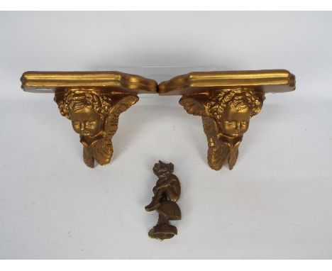 A pair of gilt plaster wall sconces decorated with putto and a vintage brass door knocker in the form of a Polperro Pisky.