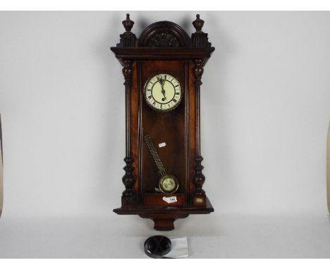 A timepiece spring driven Vienna style wall clock, two-piece enamel dial with Roman numerals and decorative blued steel hands