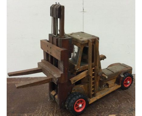 A large wooden model of a fork lift truck. Est. £20 - £30.