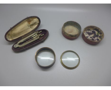 A mapping tool and a magnifying glass, both cased 