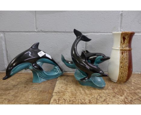 A Poole vase and two dolphin figures 