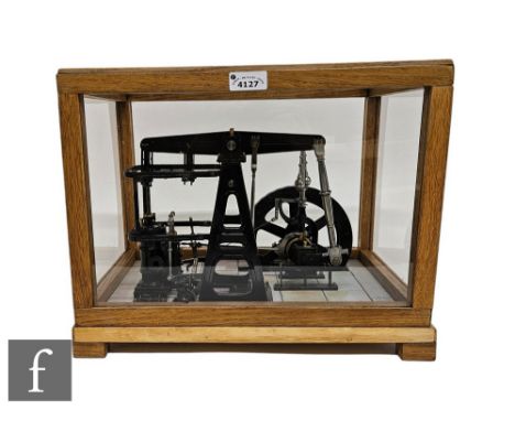 A 20th Century black painted scale model of a beam engine with spoked flywheel on simulated brick base in glazed case, 30cm x