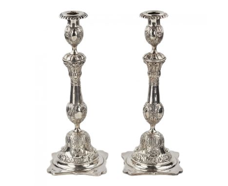  A pair of tall silver Shabbat candlesticks with floral relief ornaments. The candlestick is mounted on a rectangular base. H