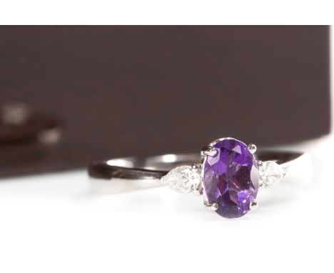 AMETHYST AND DIAMOND RING, the central oval amethyst approximately 0.75 carats, flanked by two pear shaped diamonds totalling