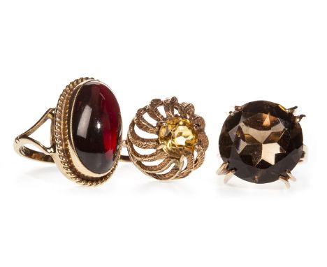THREE LATE 20TH CENTURY DRESS RINGS, including one set with an oval cabochon red gem, in nine carat gold, size K, two in nine