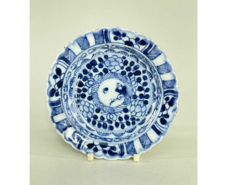 CHINESE BLUE & WHITE SAUCER, Kangxi, painted with a boy in a roundel within leaves and diaper bands, scalloped rim, fluted re