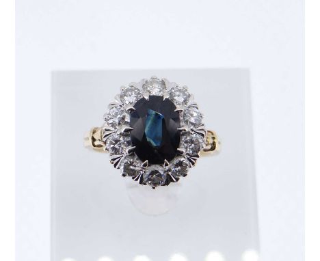 18CT GOLD SAPPHIRE &amp; DIAMOND CLUSTER RING, the central sapphire (10 x 7mms) surrounded by ten diamonds (0.07cts each appr