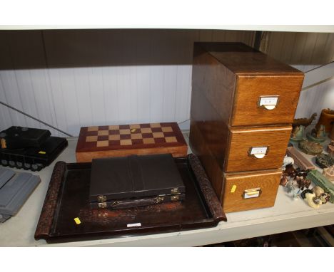 A wooden chess set and pieces; a carved wooden tray; a backgammon set and three wooden desk drawers