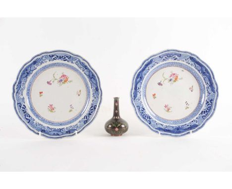 A pair of Chinese Qianlong barbed circular dessert plates, painted with scattered flowers in colours, within a "Fitzhugh" bor