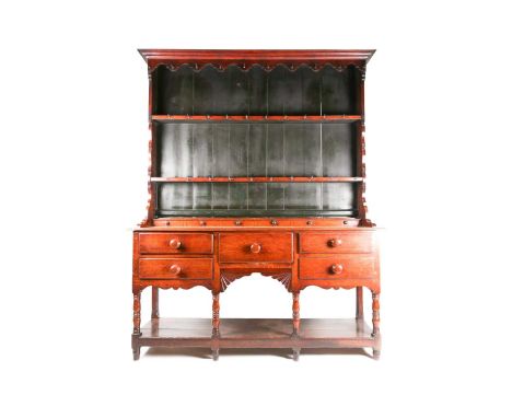 An early to mid 19th century Oak pot board dresser and rack. The base with a bank of faux spice drawers and fitted five furth
