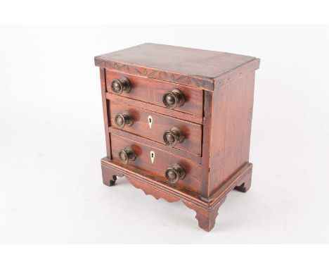 An early 19th century apprentice miniature chest of mahogany drawers, the three drawers modelled as four beneath a stained bo