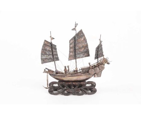 A Chinese silver study of a junk, circa 1900, the deck with three figures, five cannons and four oars, the centre mast marked