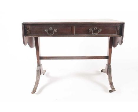 A George III style, mahogany two flap sofa table with faux and actual frieze drawers. On end, stile supports with inverted, b