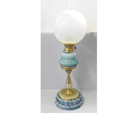 A brass oil lamp with blue glass reservoir and pottery base, replacement shade 