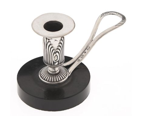 A William IV silver hand candlestick, the sconce applied with palmettes, having loop handle, on associated noir belge base, 9
