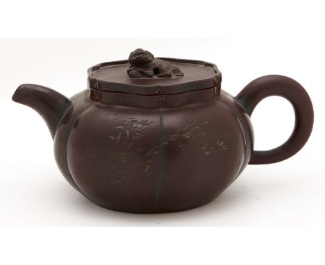 A Chinese Yixing teapot and cover,&nbsp; the six lobed teapot carved with bamboo and calligraphy, the sunken cover with dog o