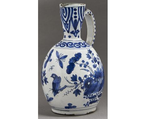 A Dutch delftware&nbsp; ewer, 18th c, painted in Japanese style with larger groups of flowering plants and a comical bird on 