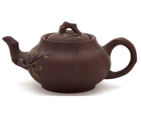 A Chinese Yixing&nbsp; stoneware teapot and cover,&nbsp;applied with prunus issuing from the root shaped spout handle and kno