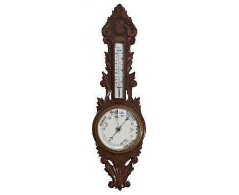 An Edwardian carved oak aneroid barometer, with mercury thermometer, 91cm h  Good condition. Note barometer untried, sold as 