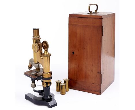 A brass compound microscope, c1900, with eyepiece and two E Leitz objectives to the nose piece, universal joint, on horseshoe