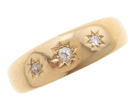 A three stone diamond ring, gypsy set, on gold band marked 18ct, 5.4g, size Q½  Light wear